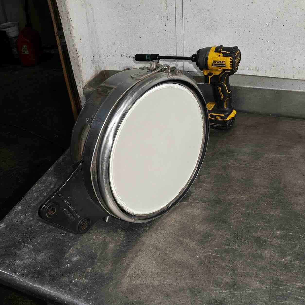 Carcasa circular de DPF limpio junto a herramienta DeWalt